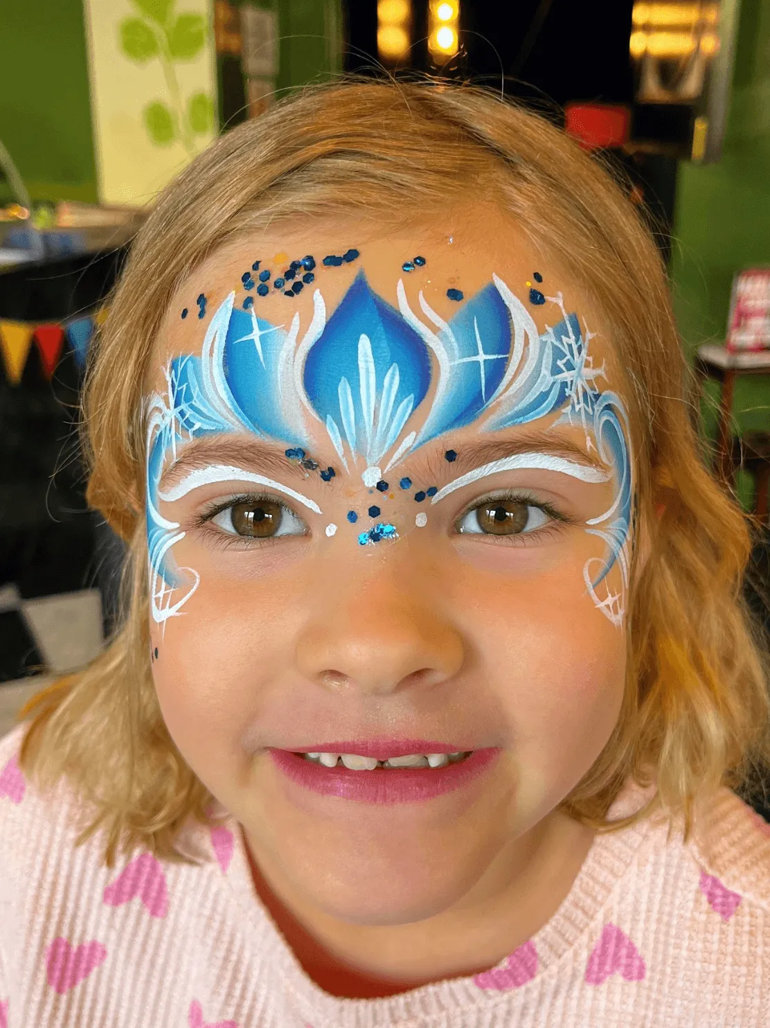 A kid proudly displaying an amazing facepaint artwork