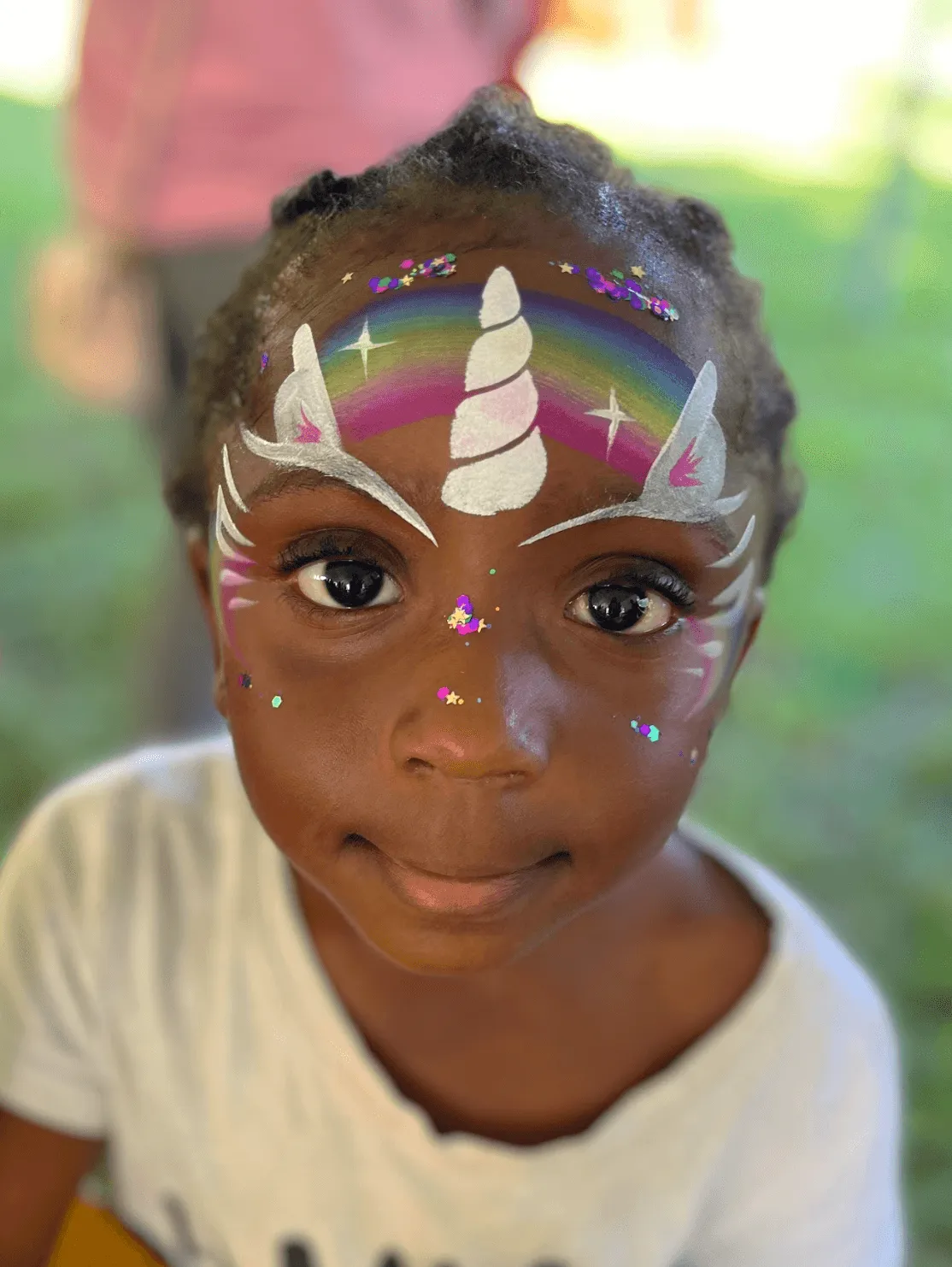 A kid proudly displaying an amazing facepaint artwork