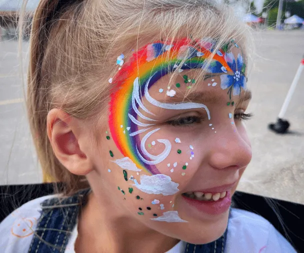 A kid proudly displaying an amazing facepaint artwork