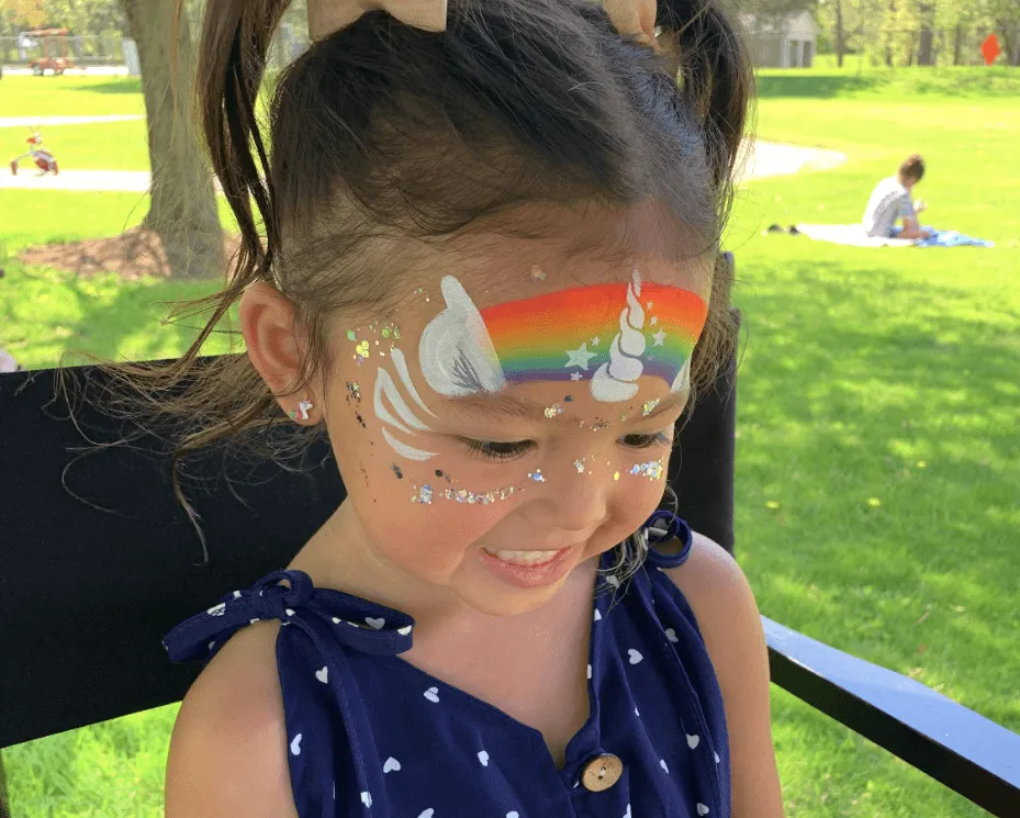 A kid proudly displaying an amazing facepaint artwork