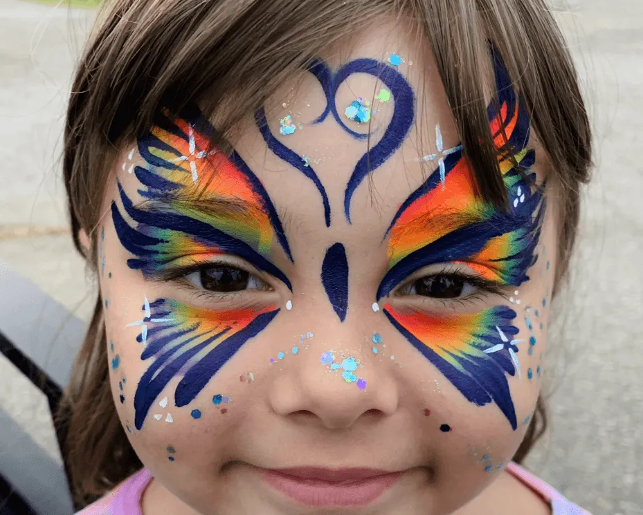 A kid proudly displaying an amazing facepaint artwork